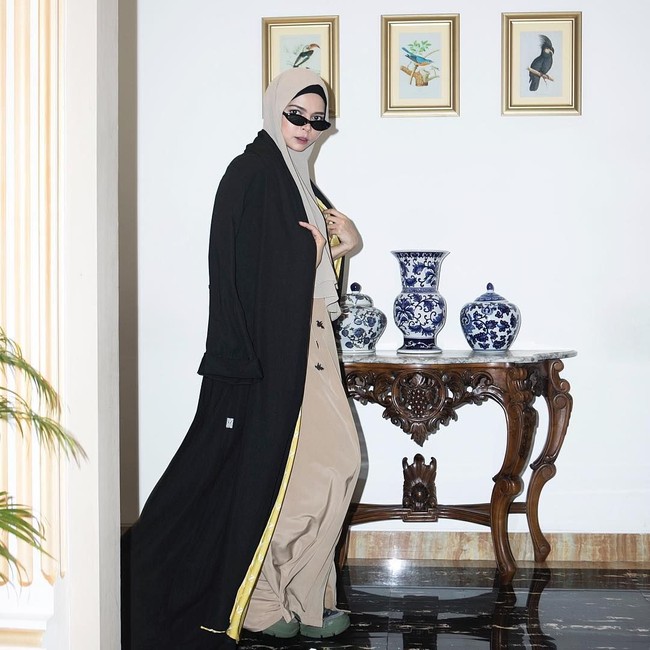 Agar tak terlihat berlebihan dan tetap sopan, ia memadukan sneakers hijau dengan gamis bernuansa beige. Foto: Instagram