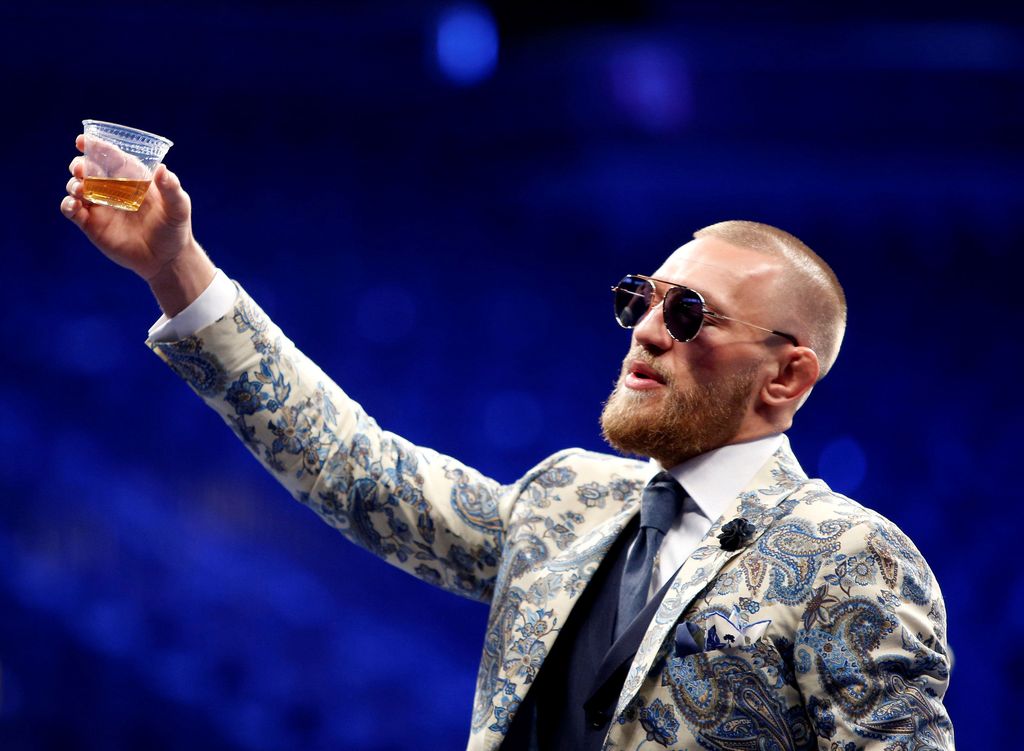 FILE PHOTO: UFC lightweight champion Conor McGregor of Ireland raises a cup of Irish whiskey during post-fight news conference at T-Mobile Arena in Las Vegas, Nevada, U.S. August 27, 2017. REUTERS/Steve Marcus/File Photo