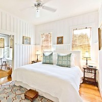 Rumah memiliki empat kamar tidur utama yang didominasi elemen kayu dan nuansa putih. Kamar tidur cukup luas dan terdapat sofa panjang untuk bersantai atau baca buku sebelum tidur. Foto: dok. The Sun