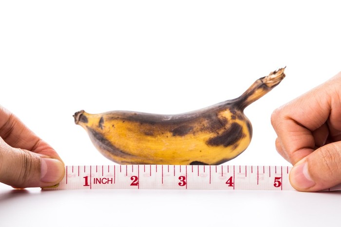 banana and measuring tape on white background