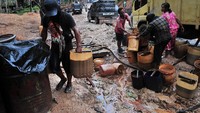 Sejumlah warga mengumpulkan limbah minyak mentah di lokasi pengeboran minyak ilegal. Antara Foto/Wahdi Septiawan.
