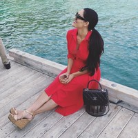 Ia juga mengoleksi tas Chanel. Seperti Chanel flap-bag hitam ini yang berpadu apik dengan shirt dress merah dan wedges coklat. (Foto: Instagram @thenikkibella)