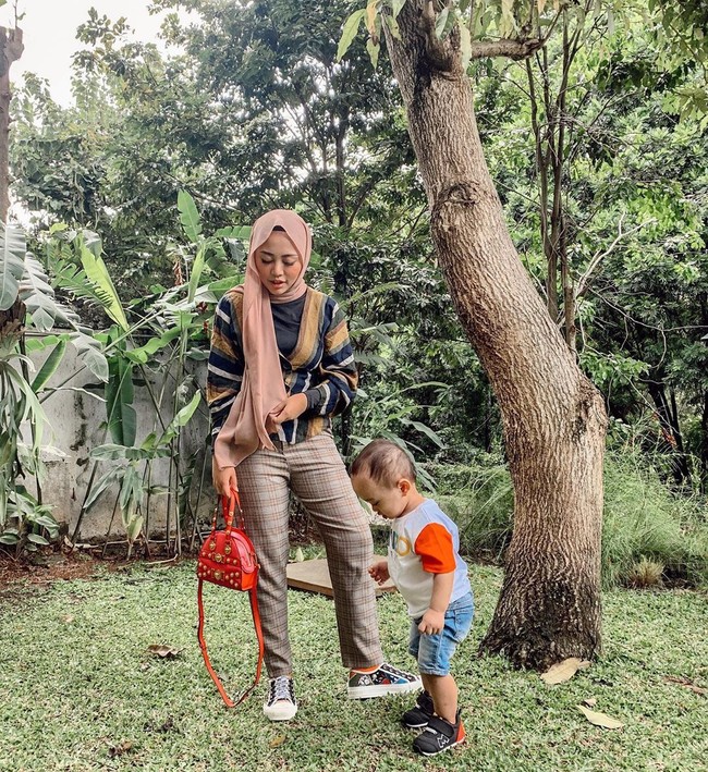 Berpose bersama buah hatinya, Xabiru, Rachel bergaya stylish memadupadankan sneakers Dior seharga Rp 23 juta dengan tas Versace yang harganya mencapai Rp 34 juta. Foto: Instagram @rachelvennya