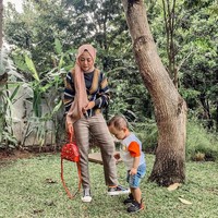 Berpose bersama buah hatinya, Xabiru, Rachel bergaya stylish memadupadankan sneakers Dior seharga Rp 23 juta dengan tas Versace yang harganya mencapai Rp 34 juta. Foto: Instagram @rachelvennya