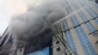 Petugas pemadam kebakaran berusaha memadamkan api yang membakar gedung bertingkat tersebut. Reuters/Mohammad Ponir Hossain.