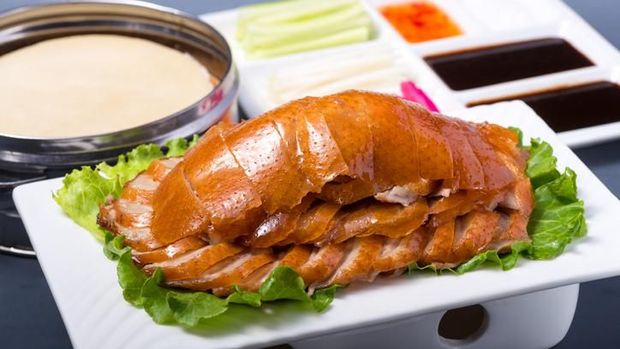 Traditional chinese peking duck dish served on wooden table
