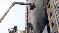 Petugas pemadam kebakaran berupaya memadamkan api dan mengevakuasi korban yang terjebak di dalam gedung yang terbakar. Reuters/Mohammad Ponir Hossain.