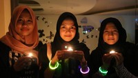 Warga menyalakan lilin di salah satu hotel di Surabaya, Jawa Timur, Sabtu (30/3/2019). Aksi mematikan lampu selama 60 menit untuk Earth Hour tersebut merupakan aksi bersama untuk mengurangi laju perubahan iklim. ANTARA FOTO/Didik Suhartono