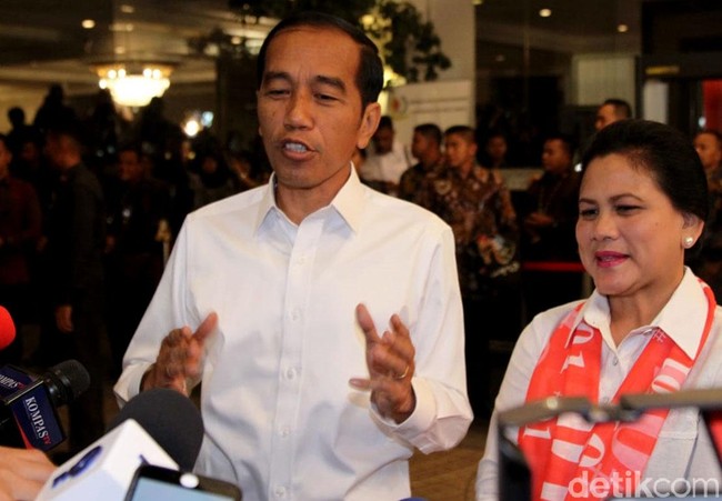 Kali ini, Iriana memadukan kemeja tersebut dengan scarf berwarna merah. Istimewanya, scarf tersebut dihiasi tulisan 01. Untuk menyempurnakan gayanya, Iriana memakai anting mutiara yang meninggalkan sentuhan elegan. Foto: Rifkianto Nugroho