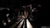 Penduduk setempat berkumpul di sebuah gerobak jajanan selama pemadaman listrik di Caracas, Venezuela. REUTERS/Ivan Alvarado