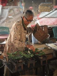 Nenek penjual otak-otak. Lensa kit, f/4.5, ISO 5000.