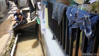 Warga membersihkan rumahnya yang sempat terendam banjir.