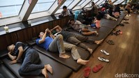 Para penumpang beristirahat di dalam kapal. Fasilitas di dalam kapal berbeda dengan kapal-kapal di dermaga biasa. Kapal ini lebih bersih dan tertib.