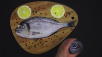 Tidak selama pembuatan steak, ikan mentah utuh lengkap dengan potongan lemon ini membutuhkan waktu selama dua jam untuk dibuat. Tiap karya yang ia buat selalu disiram atau disapu dengan tangan agar penontonnya yakin kalau gambar buatannya benar-benar dari garam. Foto: YouTube bashirsultani