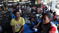 Warga menggelar alas untuk beristirahat di salah satu area bekas kebakaran yang berada di kolong tol Pluit, Jakarta Utara.