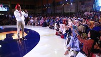 Sandiaga yang memakai Songkok Passapu warna merah menyapa para milenial yang memadati Celebes Convetion Center .