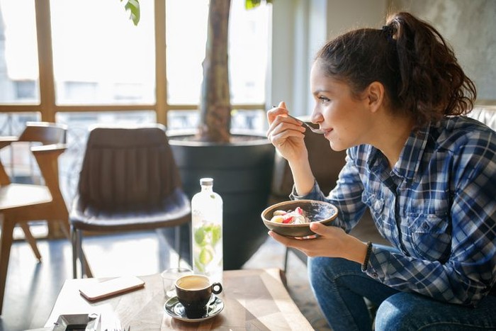 travelling Woman eating cereals with yogurt for breakfast