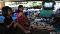 Anak-anak nampak menonton televisi di area bekas kebakaran kolong tol Pluit, Jakarta Utara.