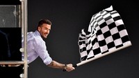 Bintang sepakbola Inggris David Beckham membuat penampilan tak terduga di ajang balapan F1 GP Bahrain pada Minggu (31/3/2019), ia menjadi pengibar bendera finis dalam acara tersebut. Andrej Isakovic/Pool via Reuters.