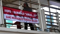 Spanduk tersebut bertuliskan #KPU - BAWASLU AWAS...!!! KAMI MENGAWASI KALIAN.
