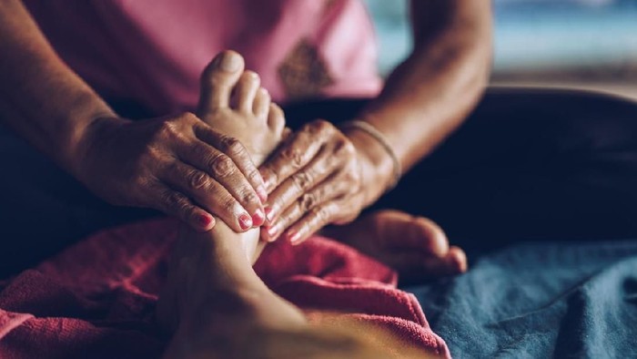 Close up of unrecognizable therapist massaging womans foot at the spa.