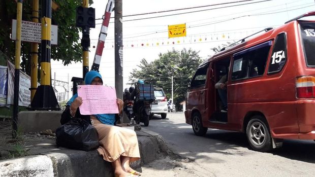 Sumiatu duduk di trotoar di dekat Stasiun Bekasi.