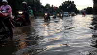 Jalan yang tergenang membuat lalin di lokasi menjadi macet.