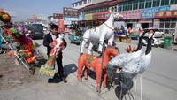 Seorang penjual menjajakan barang dagangannya berupa hiasan hewan dan bunga-bungaan jelang Festival Qingming.