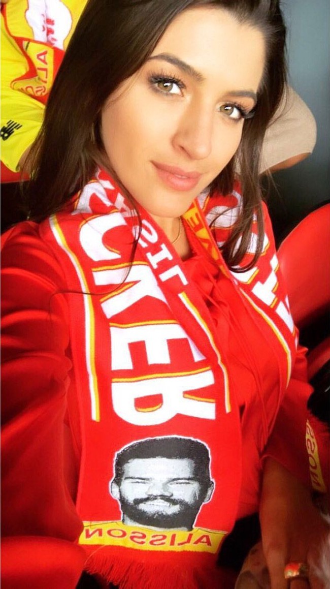 Natalia Loewe Becker yang merupakan seorang dokter itu selalu setia menonton sang suami bertanding, baik ketika Alisson Becker masih menjadi kiper Internacional hingga kini Liverpool dan menjadi kiper terbaik Premier League. Seperti inilah penampilan Natalia saat berada di barisan penonton pertandingan Liverpool. Dia memakai syal merah bergambar wajah suaminya. Foto: Instagram @ natalialbecker