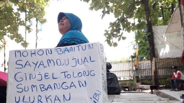 Sumiati membawa sebuah kardus dan karton yang bertuliskan 'saya mau jual ginjal'.