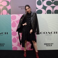 Nia Ramadhani muncul dalam balutan busana serba hitam nan edgy yang terdiri dari shirt dress dan bikers jacket kulit. Ibu tiga anak ini lalu menyempurnakan gayanya dengan lace ankle boots merah yang seksi. Foto: Dok. Coach