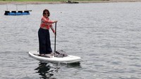 Susi bermain paddling saat mengunjungi rumah apung pemberian Kementerian Kelautan dan Perikanan (KKP) kepada Kelompok Nelayan Samudera Bakti yang berdomisili di sekitar Pantai Bangsring. Dia mengayuh board-nya berputar mengelilingi rumah apung, lalu menuju dermaga. Istimewa/Kementerian Kelautan dan Perikanan.