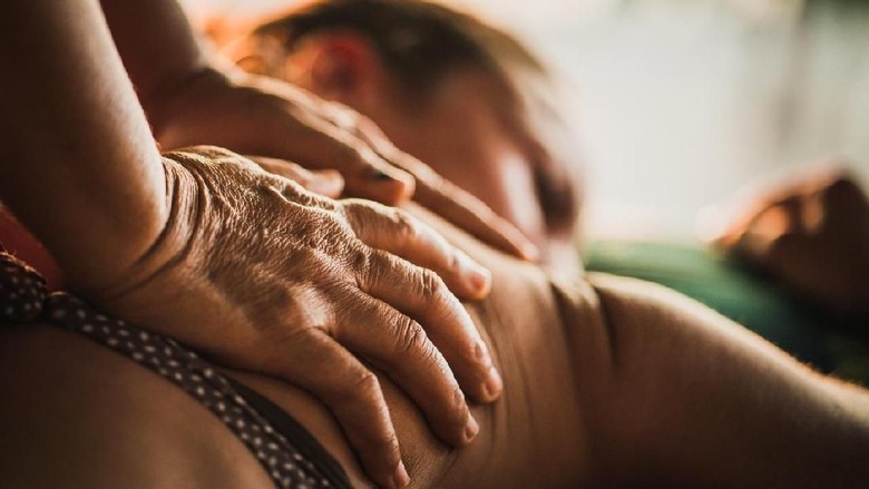 pijat, minyak terapi minyak angin minyak gosok Unrecognizable massage therapist performing reflexology on her customer at beauty spa.