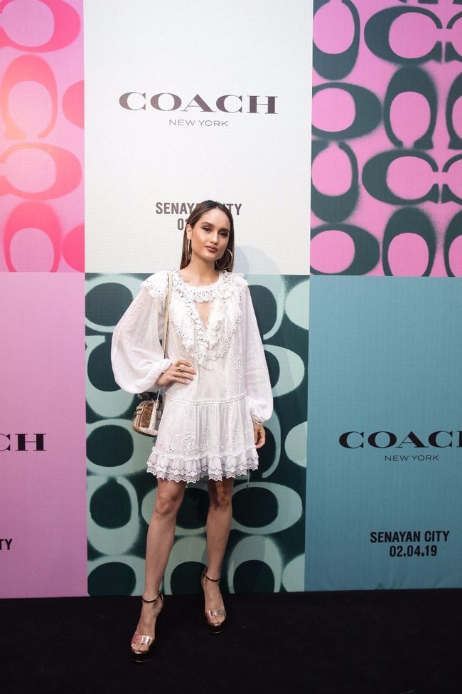 Mini dress putih bergaya boho menjadi andalan Cinta Laura. Dress tersebut hadir dengan aksen key-hole di bagian dada yang memancarkan aura seksi aktris berdarah Jerman-Indonesia itu. Foto: Dok. Coach