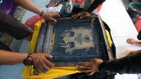 Relawan tengah menyamblon kaos Prabowo-Sandiaga.