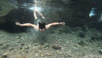 Seorang traveler berenang di kolam yang airnya jernih ini (Yudha Maulana/detikcom)