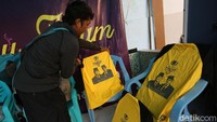 Seorang relawan menunggu hasil sablonnya kering.