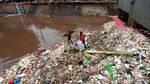 Aksi Petugas Bersihkan Sampah di Pintu Air Manggarai
