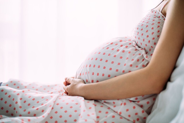 ilustrasi wanita hamil A young woman showing her pregnant belly making contact with her baby