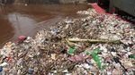 Aksi Petugas Bersihkan Sampah di Pintu Air Manggarai