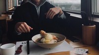 Dengan pemandangan sore yang sedikit mendung, Roy menyantap mie dengan kuah hangat sebagai menu makanannya. Foto: Instagram @roykimmusic