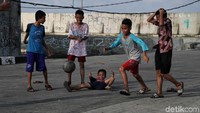 Mereka tetap riang bermain di jalan beton tersebut.
