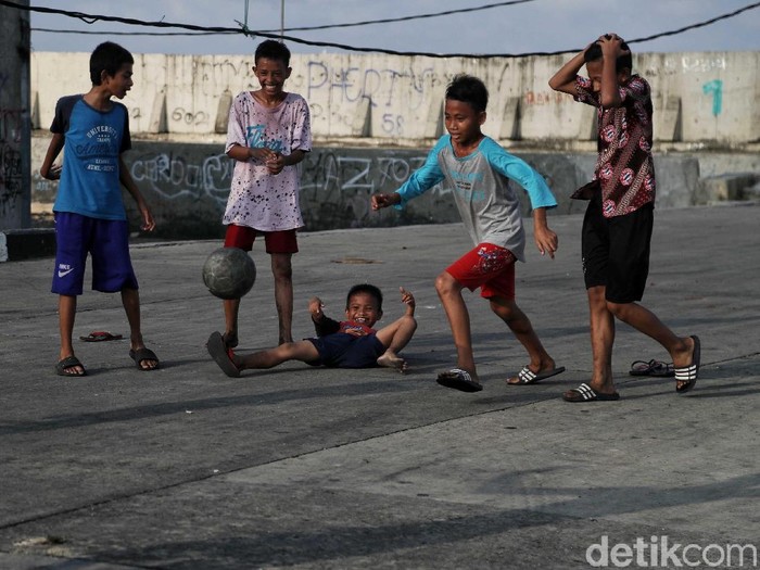 Anak-anak di kawasan Muara Baru menjadikan jalan raya sebagai arena untuk bermain. Mereka bermain sepakbola hingga burung dara di jalan tersebut.