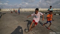 Sejumlah anak asyik bermain sepakbola di jalan depan pabrik milik Pelindo II, Muara Baru, Jakarta Utara, Jumat (5/4/2019) sore.