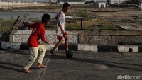 Anak-anak itu tetap bersemangat bermain sepakbola meski tak memakai sepatu.