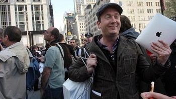 Masih dengan senyum lebar, Jacob Arentoft meninggalkan lokasi penjualan sembari menentang iPad-iPad anyarnya. Antrean Apple store di Fifth Avenue tampak kian membludak. (Foto: Spencer Platt/Getty Images)
