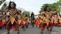 Kereta kuda Jokowi-Maruf diiringi para penghibur yang tampak mengenakan pakaian adat nusantara.