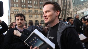 Salah satu pembeli awal iPad generasi pertama, di tengah-tengah keramaian orang yang juga hendak membeli tablet-nya Apple tersebut. Kabarnya 300 ribu unit iPad generasi pertama ini laris manis pada hari pertama penjualan. Sampai awal Mei 2010, Apple telah menjual 1 juta unit iPad. (Foto: Spencer Platt/Getty Images)