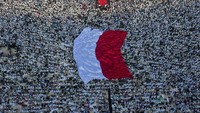 Bendera merah putih raksasa dibentangkan di tengah-tengah massa pendukung Prabowo-Sandiaga. Hafidz Mubarak/Antara Foto.