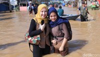 Pantauan detikcom Senin (8/4/2019), Anisa bersama temannya menerobos banjir untuk berangkat kerja di salah satu apotek di Kota Bandung. 